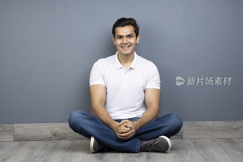 男人盘腿坐在地板上的stock photo